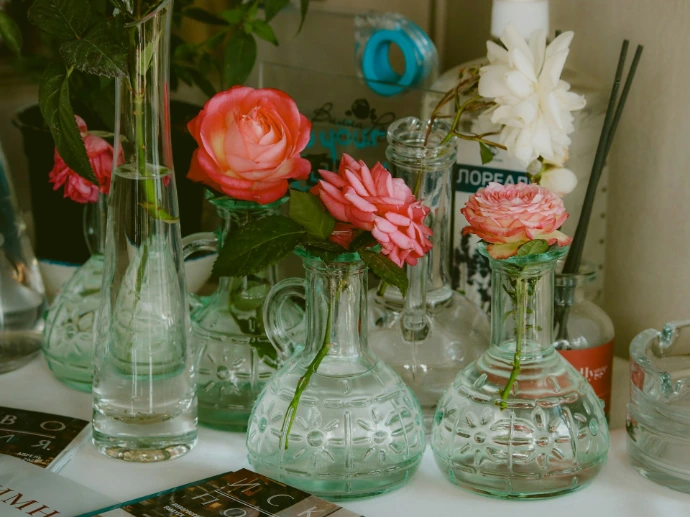 Vases of flowers are displayed on a shelf.